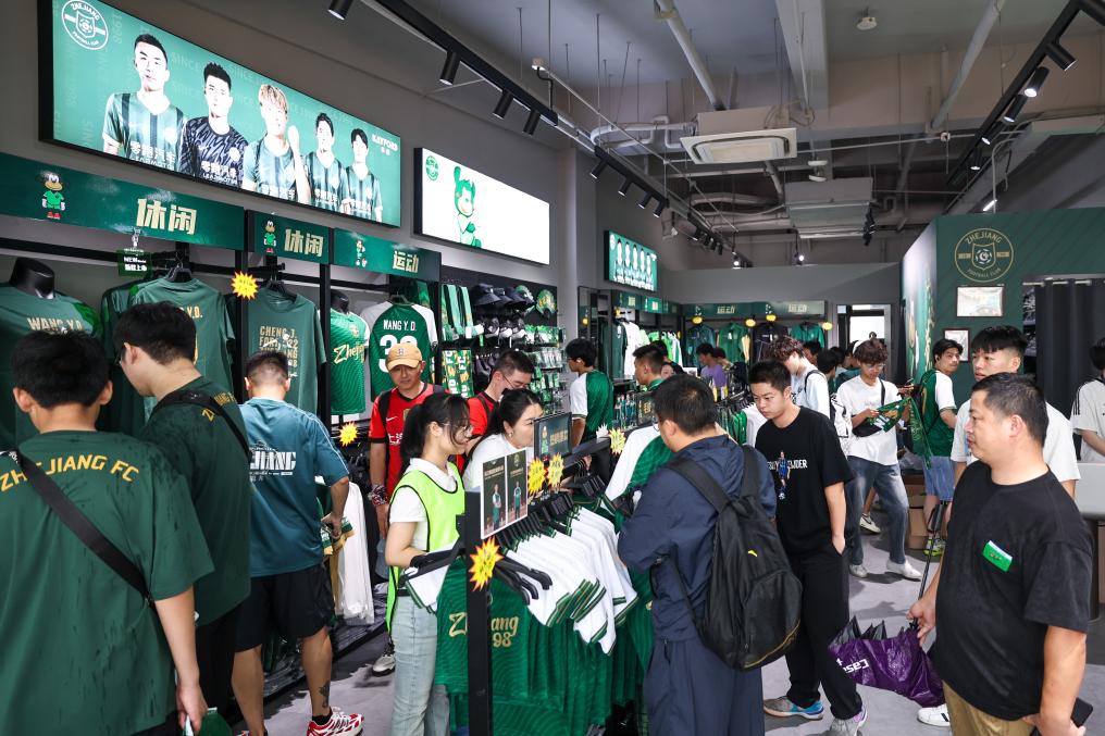 6月14日,在中超联赛浙江俱乐部绿城队对阵上海海港队的比赛前,球迷在浙江俱乐部官方商店内购物。新华社记者 江汉 摄