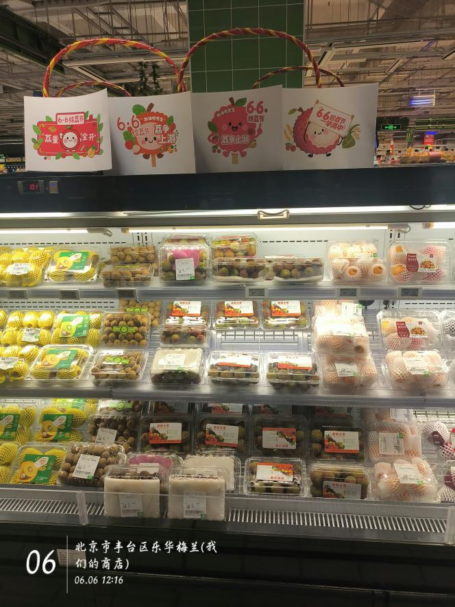 北京市丰台区的商店货架上摆放着荔枝,“6·6给‘荔’节”的宣传物料显眼。