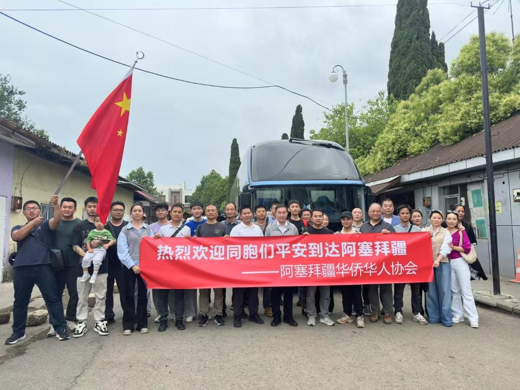 6月17日,从伊朗经阿斯塔拉陆路口岸撤入阿塞拜疆境内的中国公民与前来接应的中国驻阿塞拜疆使馆工作人员及阿塞拜疆华侨华人协会代表在阿斯塔拉口岸合影留念(手机照片)。新华社发(中国驻阿塞拜疆使馆供图)