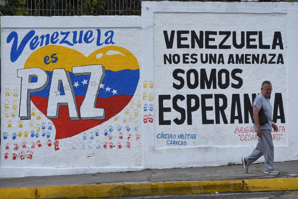  9月22日，在委内瑞拉首都加拉加斯，行人从街头的宣传标语前走过。标语上写着“委内瑞拉是和平国度”“委内瑞拉不是威胁，而是希望”。新华社发（马科斯·萨尔加多摄）
