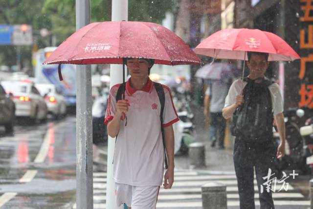 广州市天河区岳洲路,市民撑伞在雨中前行。