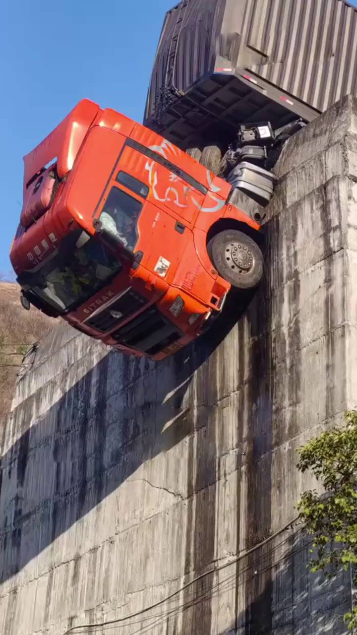 货柜车冲出公路，拖头90°悬挂半空。陕西消防