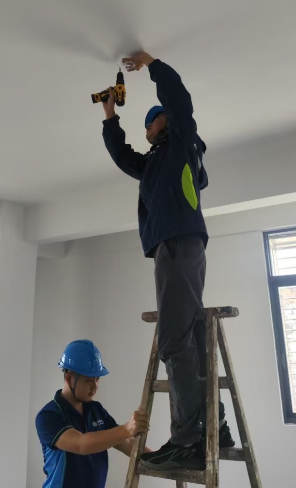 移动工作人员安装智能烟感设备。通讯员供图。
