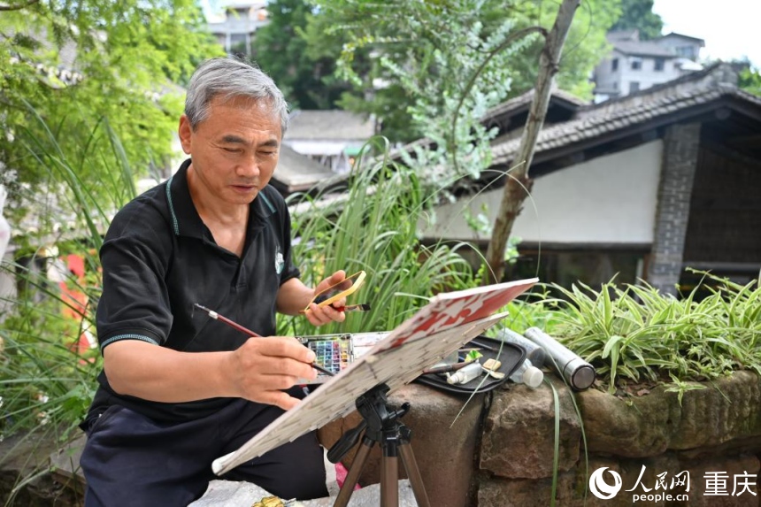 行进中国丨山城江岸,消费起新风 赵建军在下浩里老街写生。人民网 邹乐摄