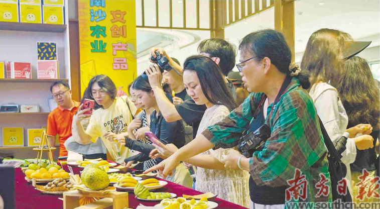 南沙都市农业实验园内,采风团成员品鉴当地特色水果。王敏杰 摄
