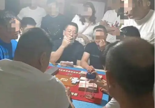 汤恕与人聚众赌博的视频截图，坐在中间戴着眼镜的抽烟男子为汤恕。