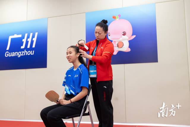 赛前江西队领队在为运动员梳理头发。