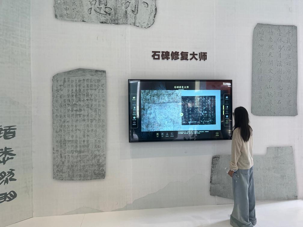 5月24日,在第二十一届文博会上,观众体验用数字技术修复石碑文字。新华社记者 陈宇轩 摄