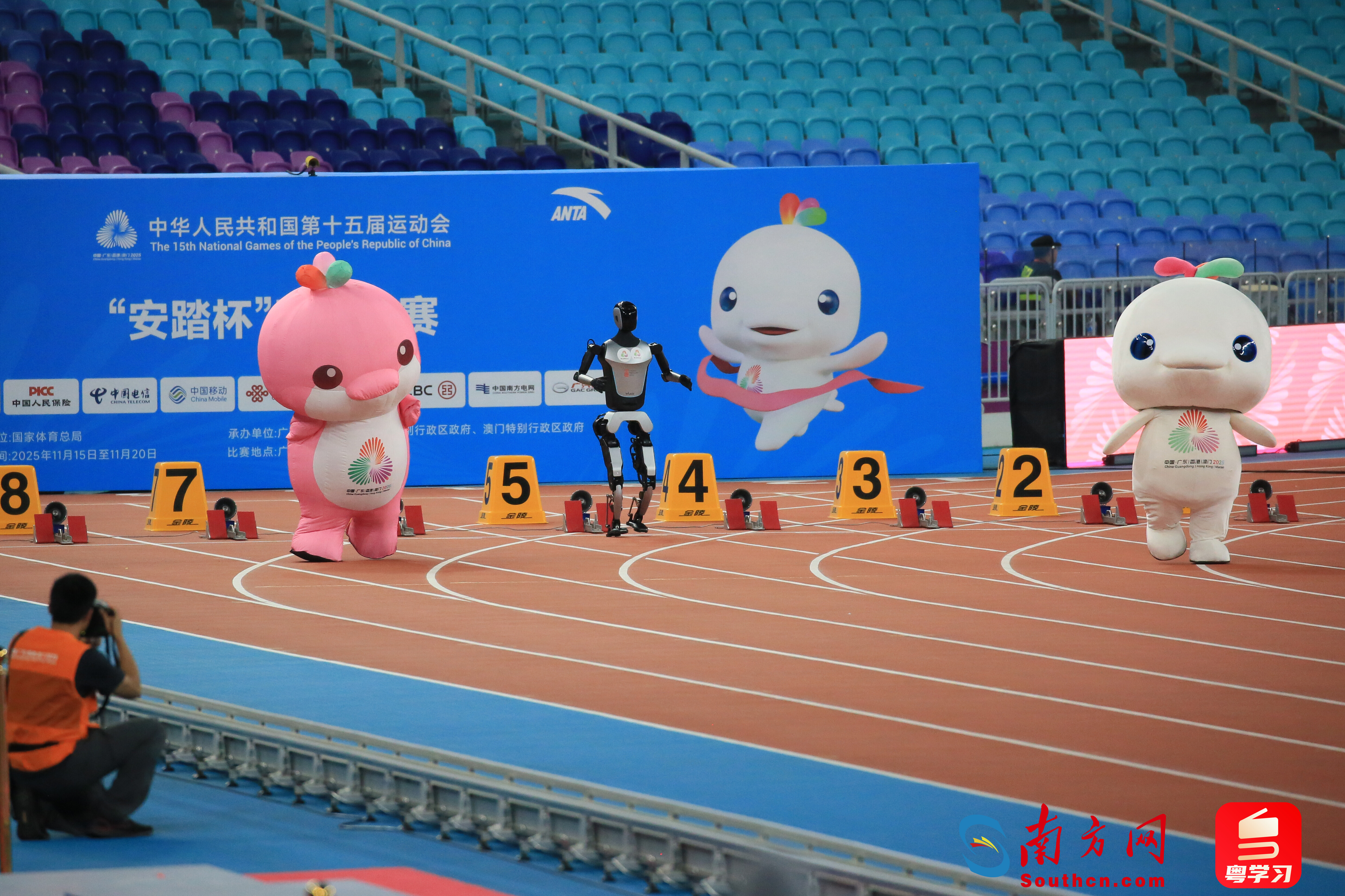 11月17日晚，吉祥物喜洋洋、乐融融与机器人在广东奥体中心比赛跑步。南方网、粤学习记者刘竞宇 摄