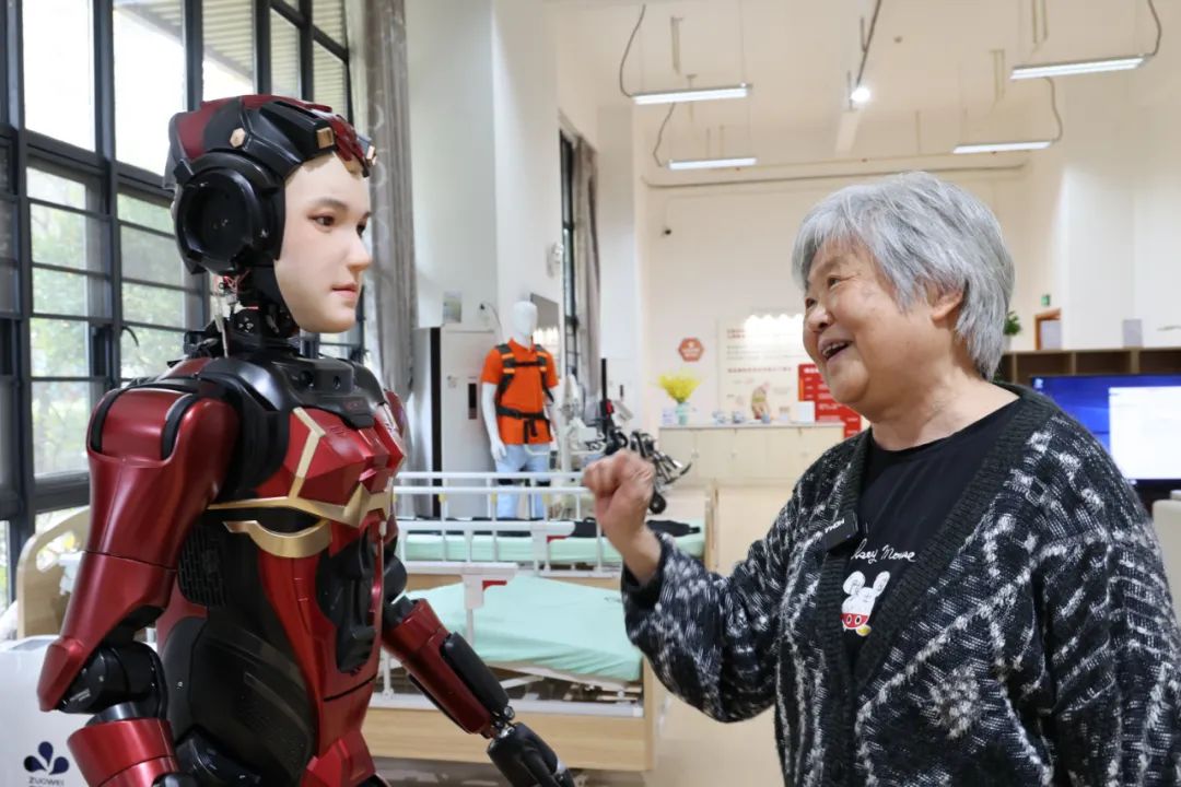 养老护理院里，一名老人与人形机器人互动。新华社记者 梁旭 摄