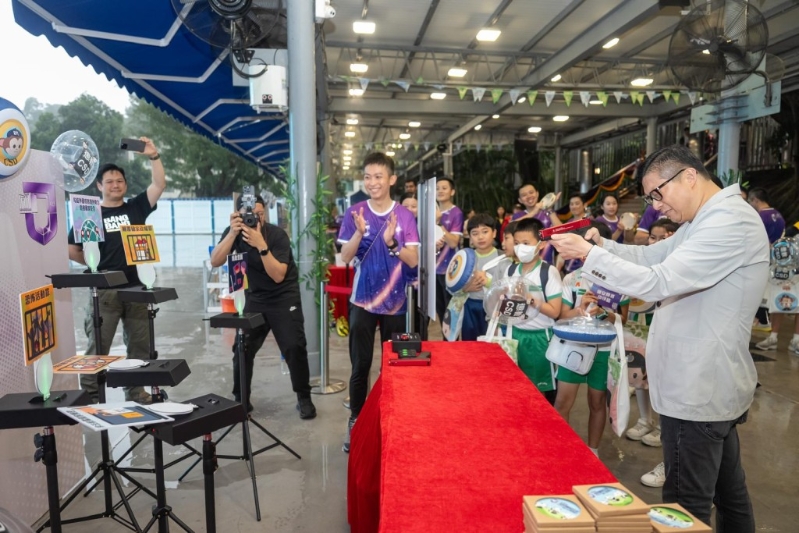 保安局局长邓炳强（右一）参与摊位游戏。政府新闻处图片