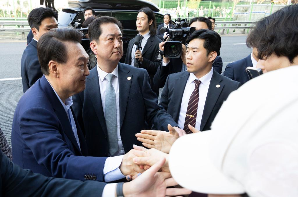 4月11日,韩国前总统尹锡悦(左一)在离开首尔汉南洞官邸时与支持者握手。新华社发(全休相摄)