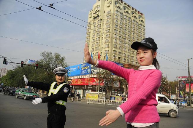 小女孩捡马路上的国旗 交警挡车流