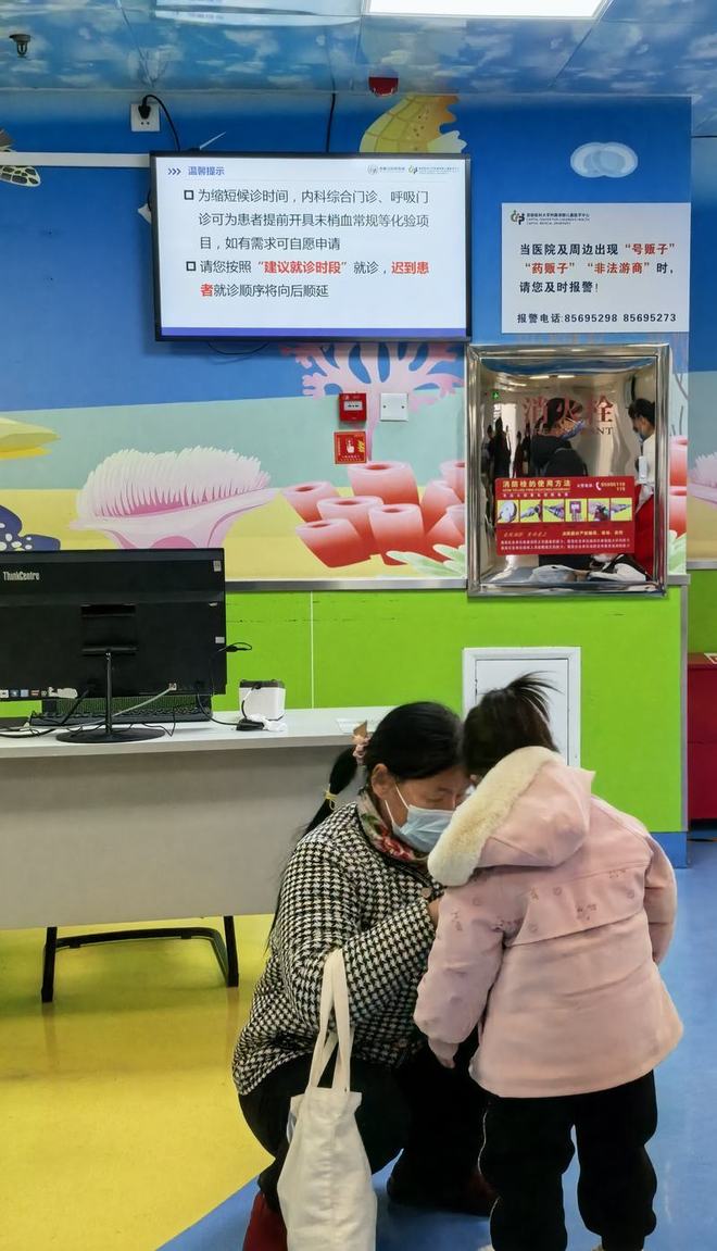 首儿所门诊大厅，大屏幕提示家长可申请诊前检查。新京报记者 戴轩 摄