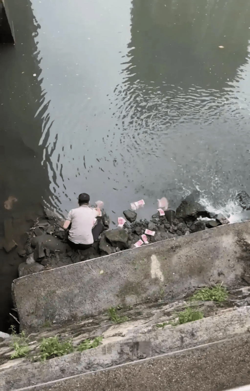 男子河道捡走河道中的现金。