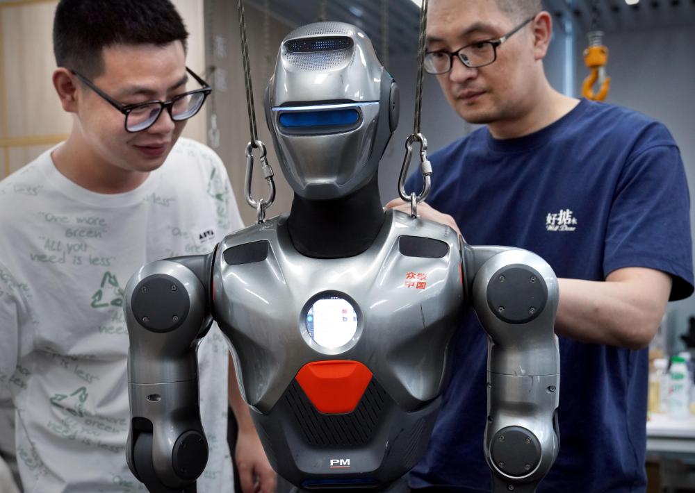 6月25日,深圳市众擎机器人科技有限公司的工作人员在调试人形机器人。新华社记者 李安 摄