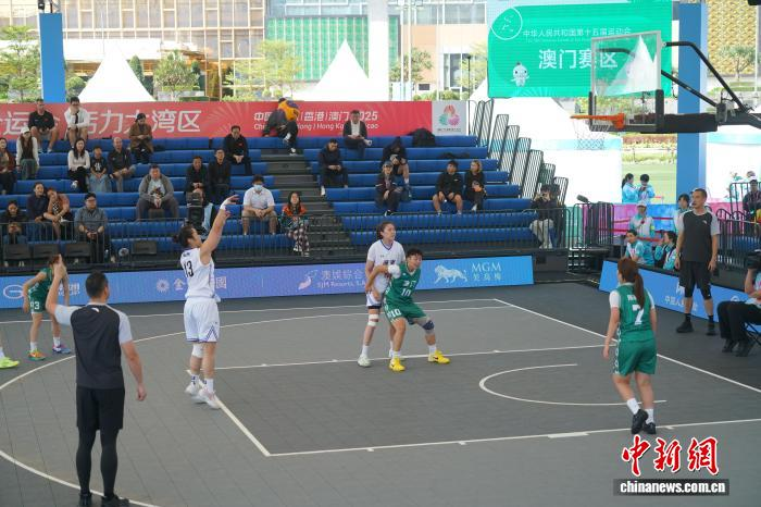 11月12日，第十五届全国运动会三人篮球赛事在澳门开赛。在女子小组赛中，广东队以21:3战胜澳门队。图为广东队(白衣)对阵澳门队。 中新社记者 郑嘉伟 摄