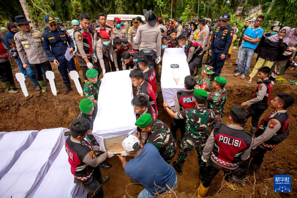 12月11日，在印度尼西亚西苏门答腊省，警察为遇难者举行集体葬礼。新华社发（安德里·马迪安赛亚摄）