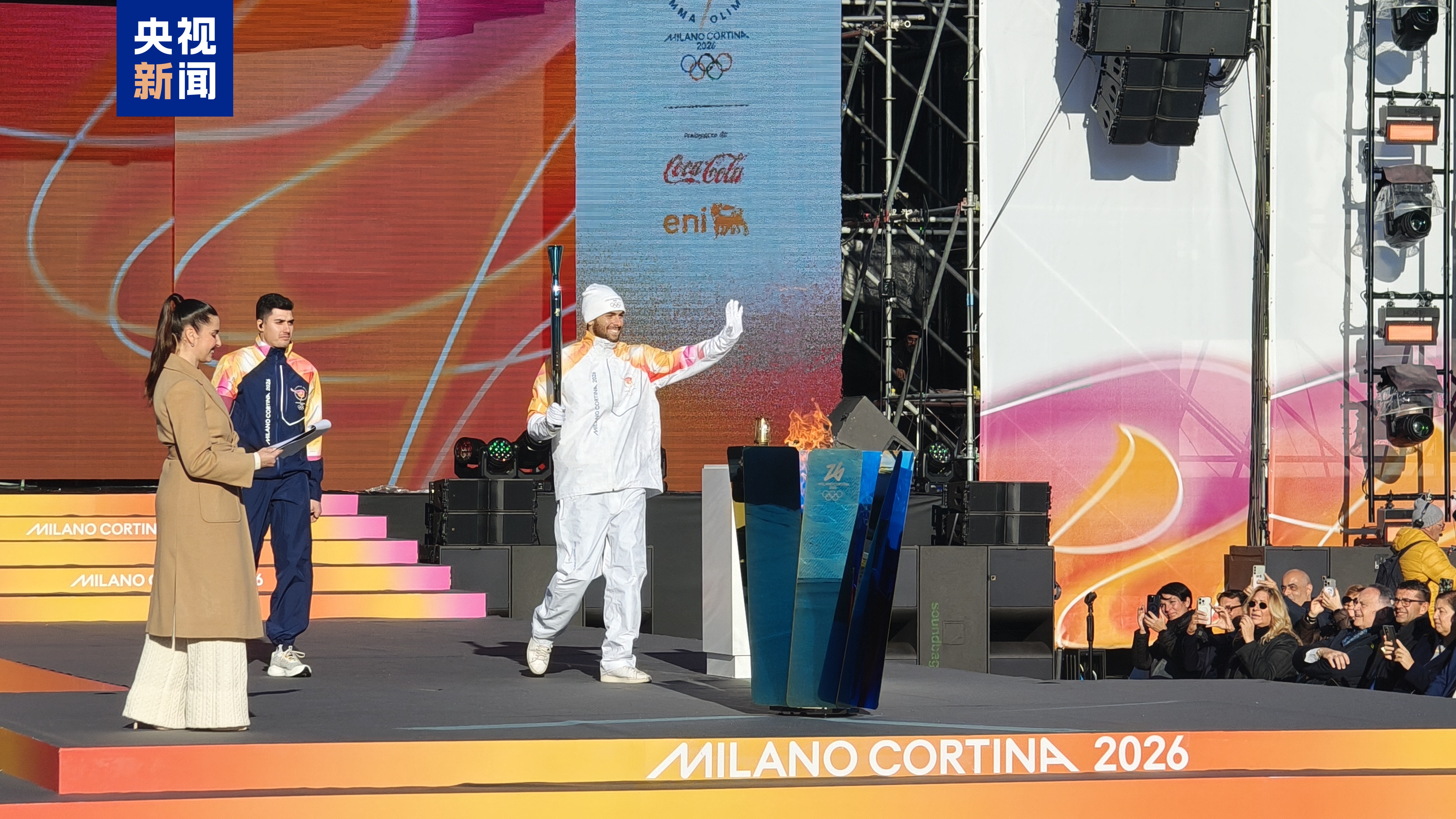 △意大利境内第一名火炬手，意大利游泳运动员格雷戈里奥·帕尔特里涅里（右一）