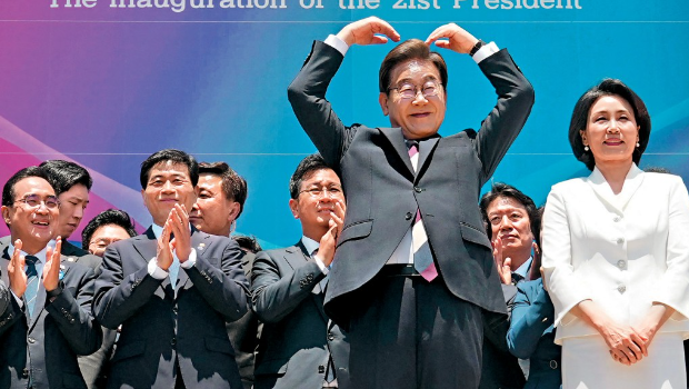 韩国新总统李在明偕夫人出席就职礼后，在国会外做出心形手势。