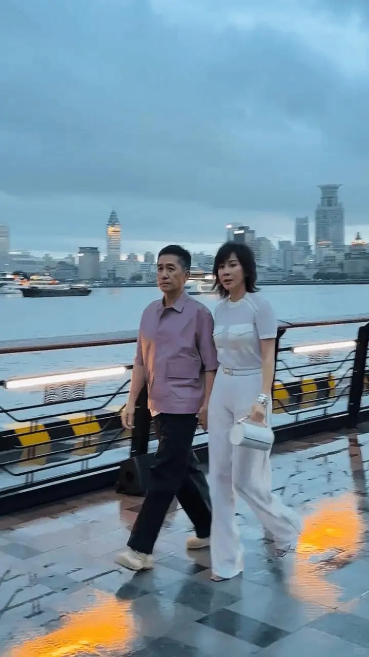 梁朝伟近日跟刘嘉玲到上海看时装秀，梁朝伟于外滩与太太牵手。