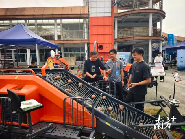 自走式甘薯联合收获机展位前，不少种植大户与农机合作社前来咨询和洽谈。