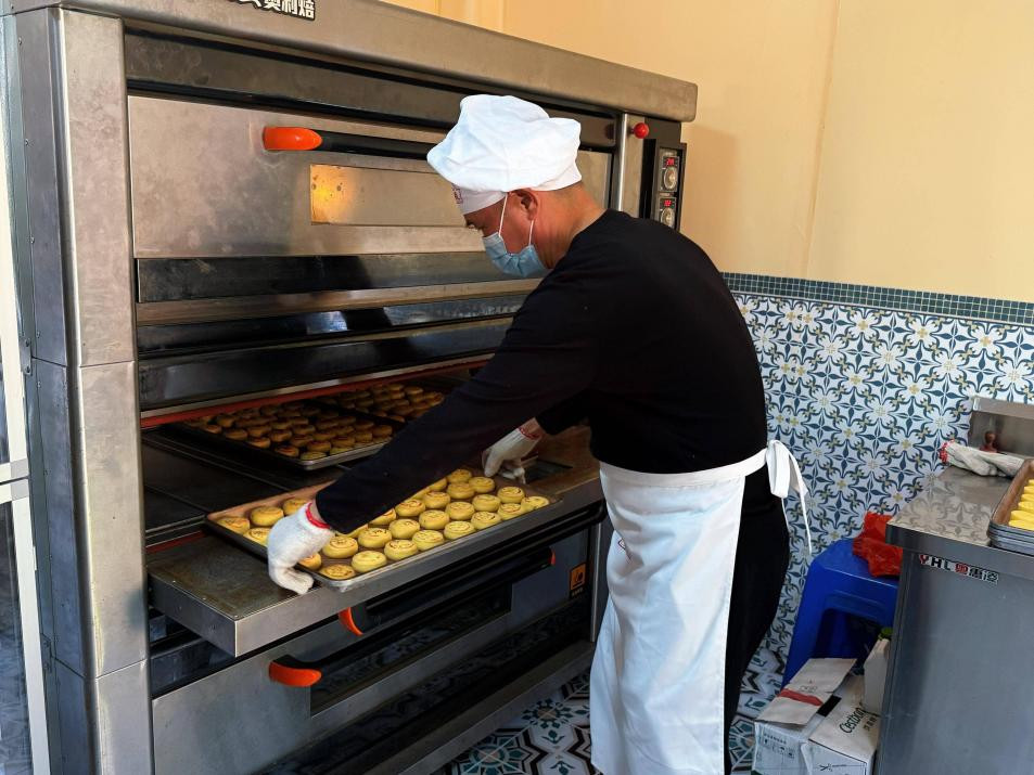 日威食品创始人翁坤昌向大家展示菊花饼的制作过程