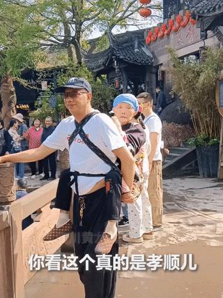 男子背妈妈旅游 妈妈在背后像个小孩