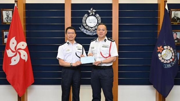 警务处处长周一鸣（右）颁授委任状予新委任香港辅助警察队副总监林俊富（左）。