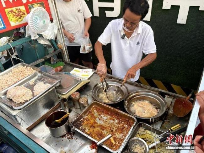 “鸡排哥”李俊永正在为食客炸制鸡排。记者 李韵涵 摄
