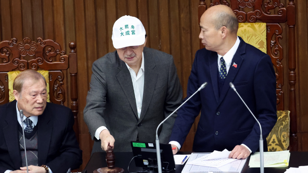 民进党团总召柯建铭（中）上到主席台，当着院长韩国瑜（右）的面拿起木槌敲击。
