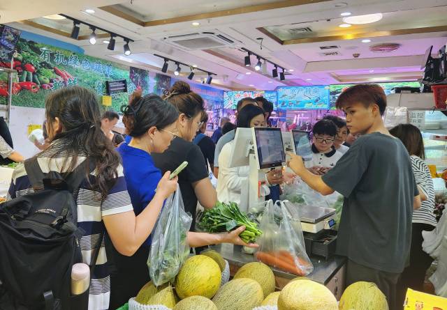 23日晚7点，广州市天河区东方三路，一家社区农贸商店，市民们正在选购新到货的大批蔬菜。 