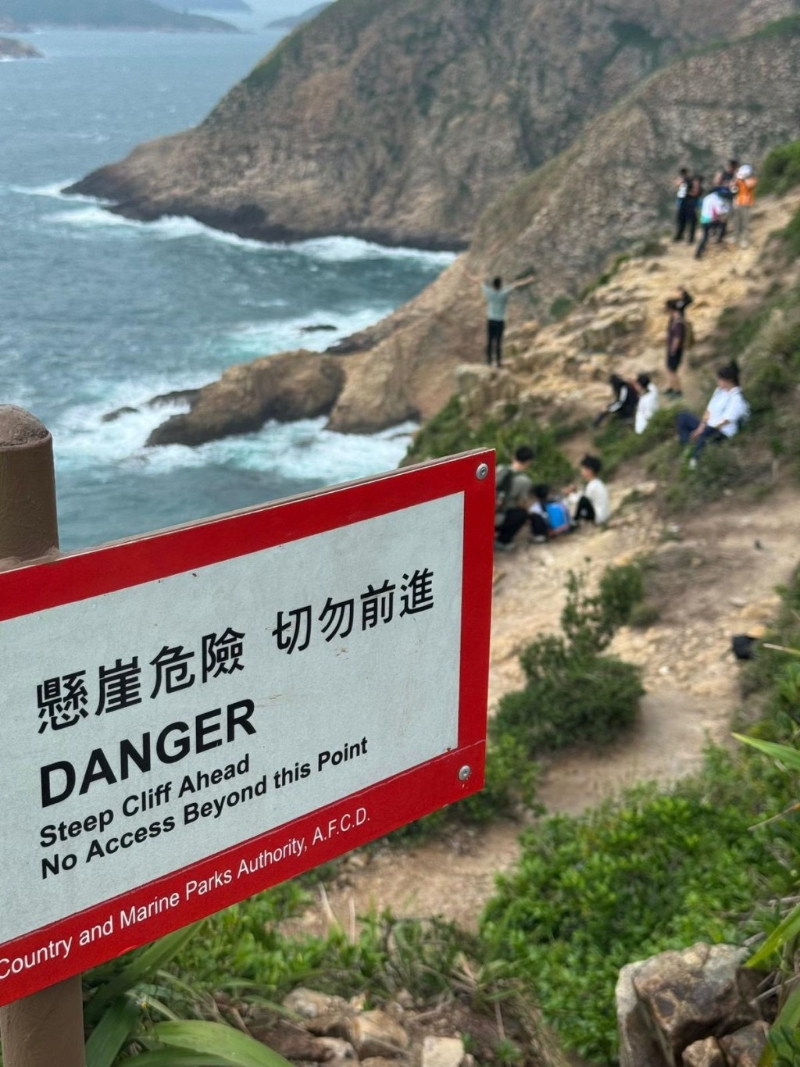 有不少游客跨过渔护署的“危坡不可越栏”警告牌,更有人在崖边张开双臂,十分危险。 有不少游客跨过渔护署的“危坡不可越栏”警告牌,更有人在崖边张开双臂,十分危险。
