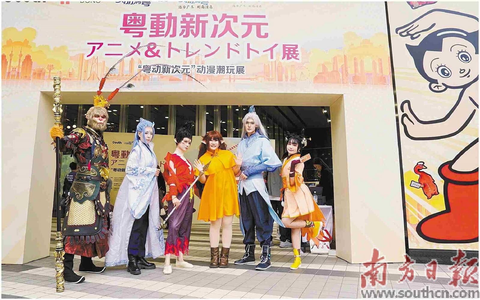 5名coser(角色扮演者)在展览现场与市民、观众互动合影。郭宏达 摄